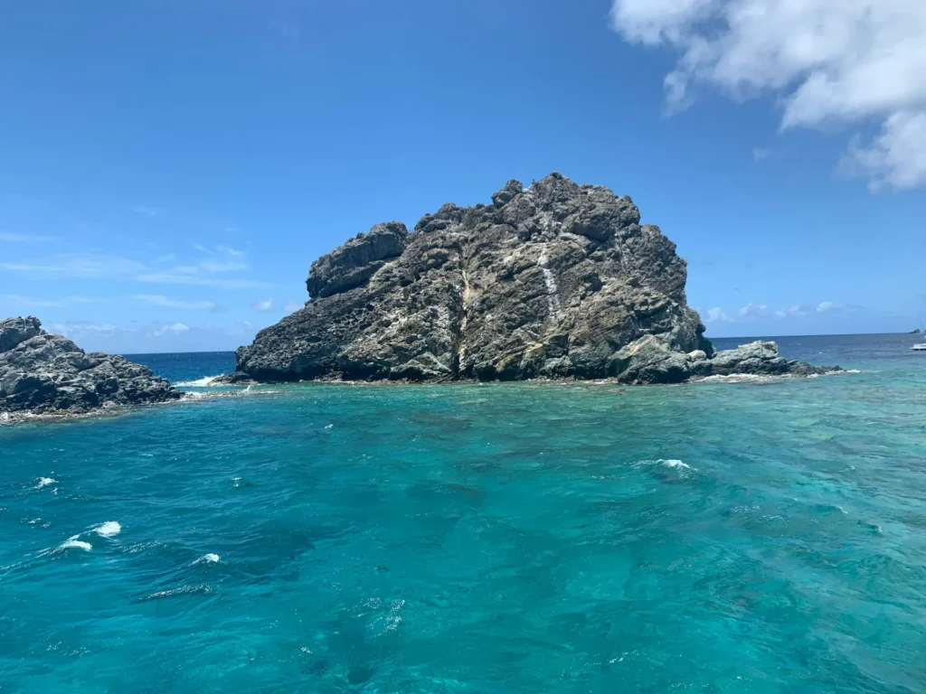 Scenic coastal view seen during a private boat charter St Maarten to St Barts, with turquoise waters and rocky islets.