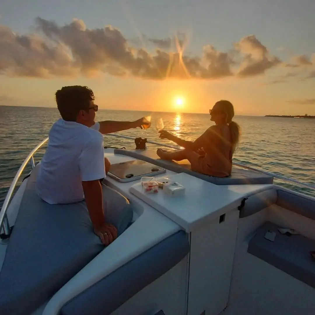Romantic sunset cruise St Maarten with couple toasting on a private boat