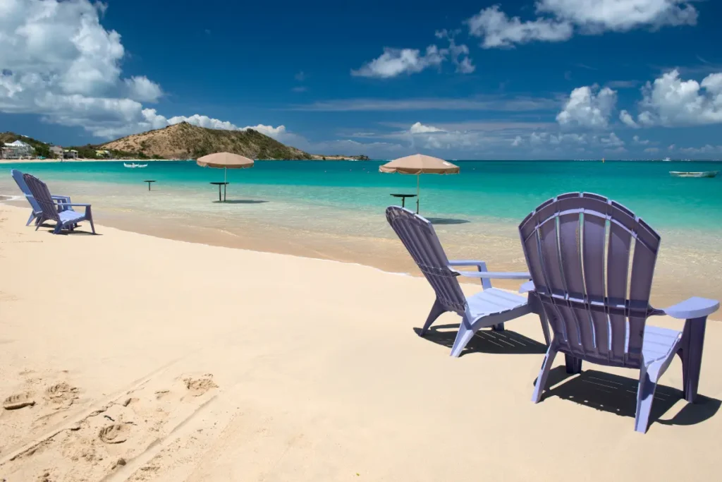 Empty beach chairs on calm waters at Grand Case Beach.