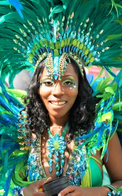 Woman in vibrant green feathered costume at St Maarten Carnival - cultural things to do in St Martin / St Maarten