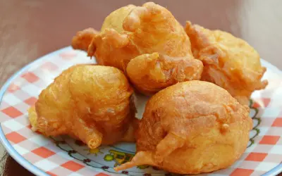 A plate of golden-brown Caribbean-style codfish fritters on a red-checkered dish. Things to do in St Martin