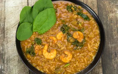 A bowl of shrimp and greens in a rich Creole stew with rice and leafy greens on the side. Things to do in St Martin