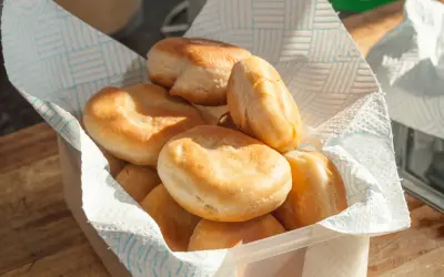 Golden-brown Johnny cakes stacked in a lined basket, ready to serve. Things to do in St Martin