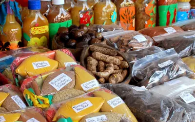 Caribbean spice market stall with packets of spices, roots, and sauces in vibrant packaging.