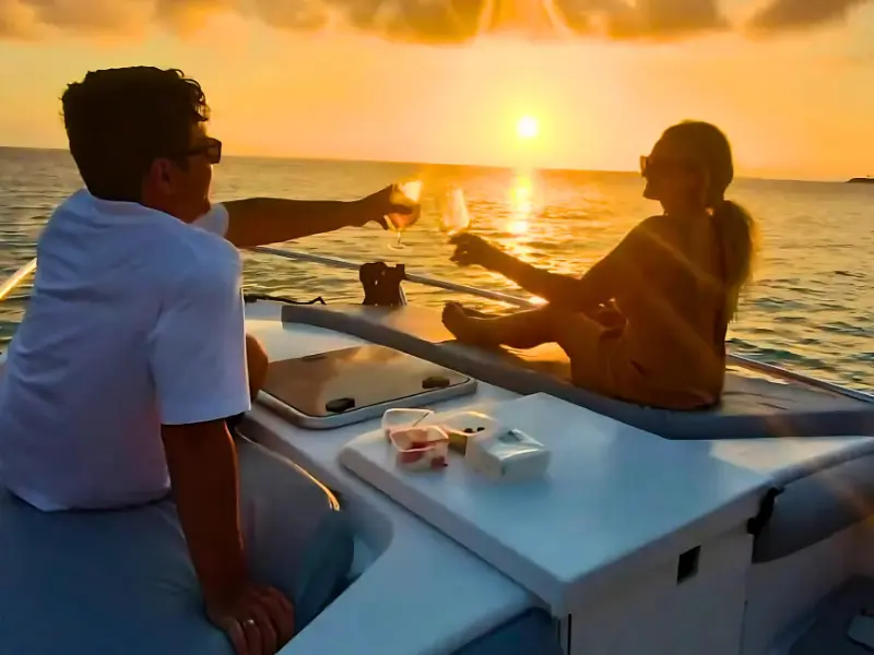 Couple enjoying champagne on private boat during Caribbean sunset