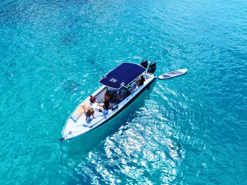 Speedboat in St Maarten turquoise waters with scenic coastline in background