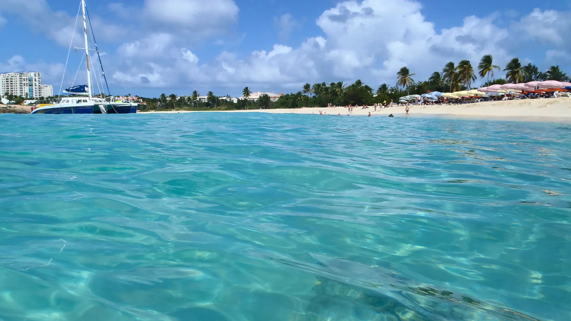 Mullet Bay Beach St Maarten with turquoise water and catamaran offshore