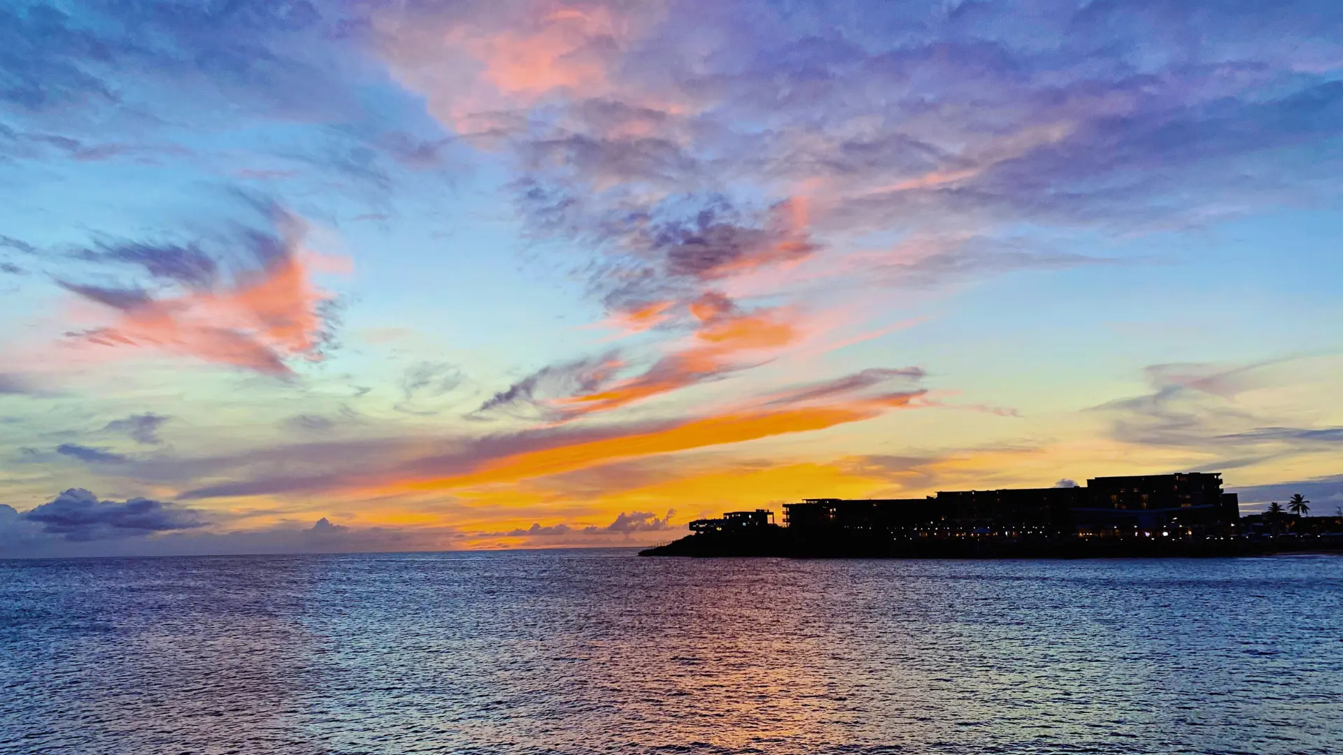 Colorful sunset over Maho Beach St Maarten with ocean horizon