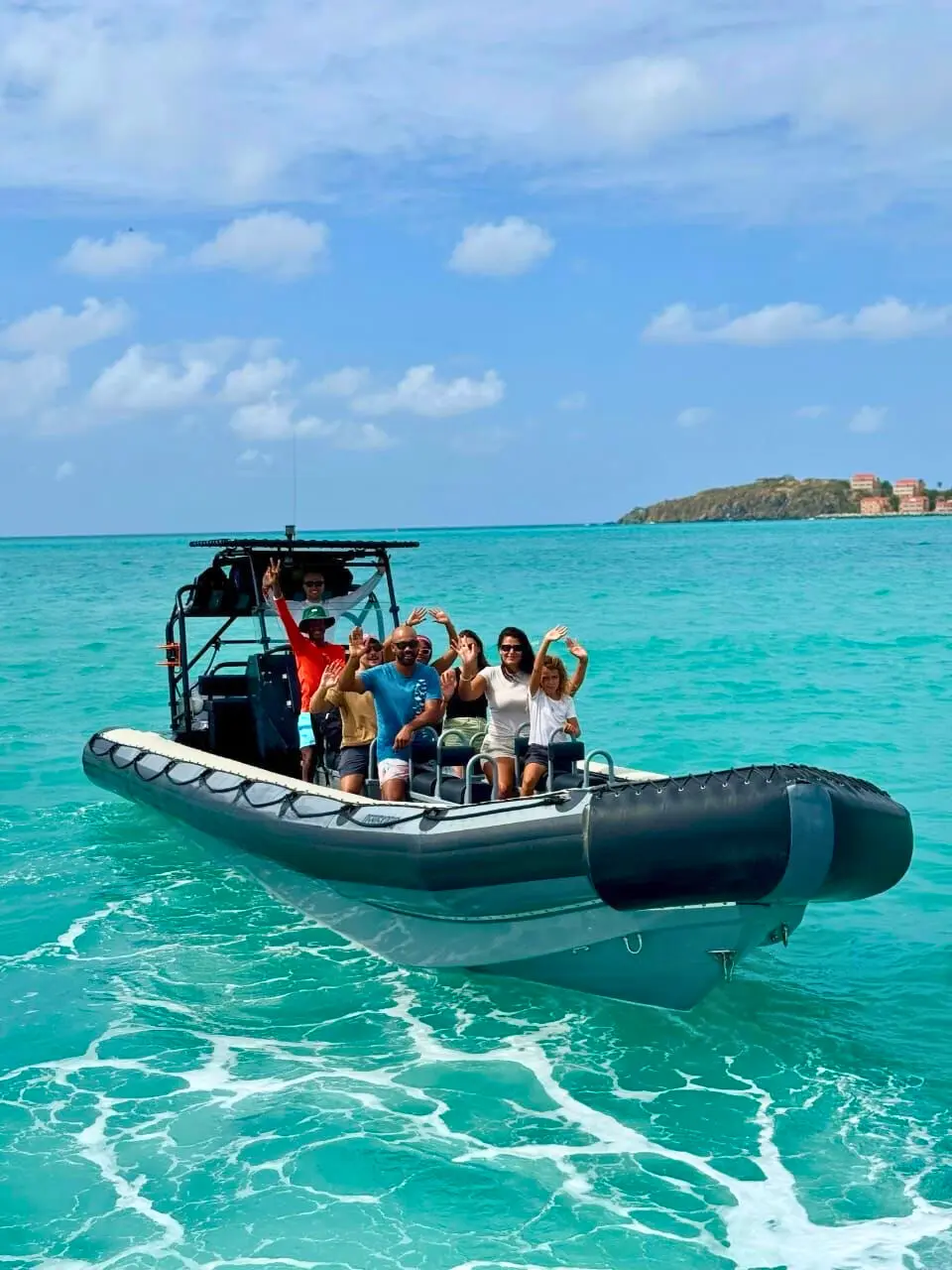 Captain Marco with smiling passengers on RIB Adventure SXM boat in calm Caribbean water.