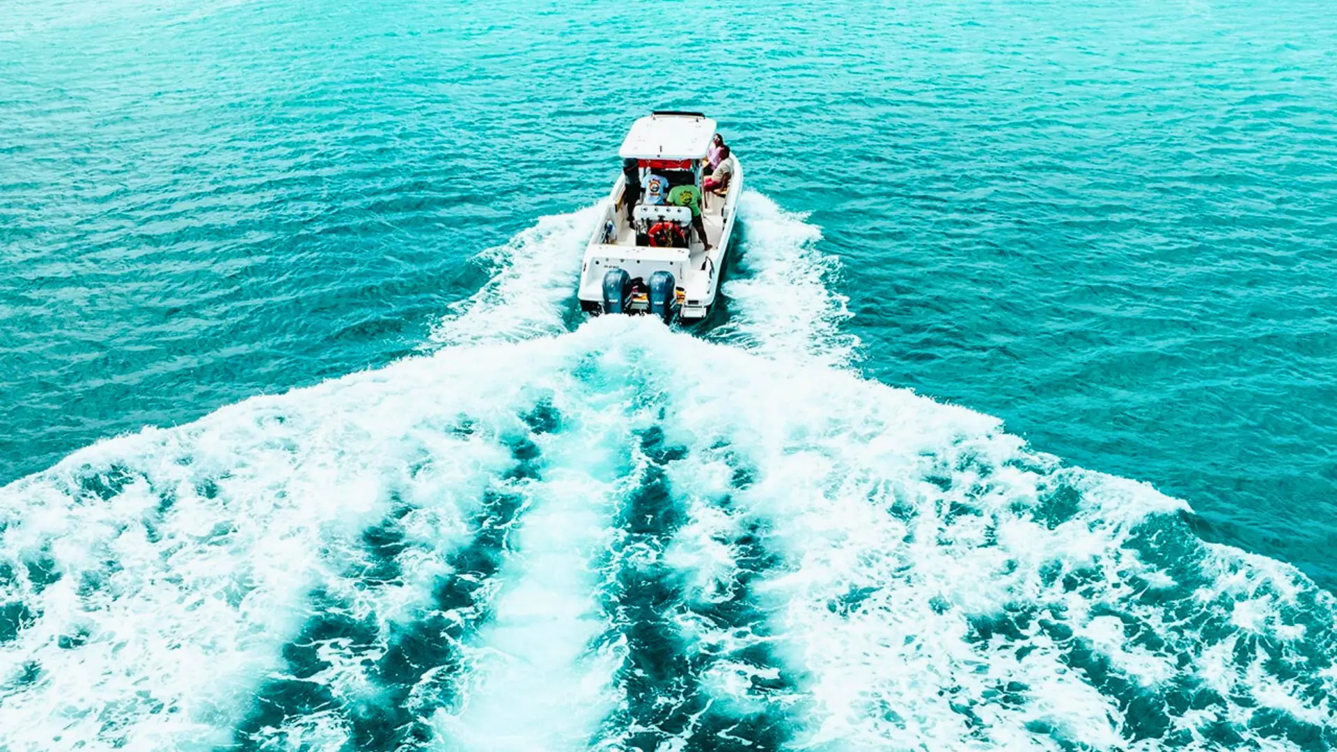 Captain navigating a 26-foot motorboat across crystal-clear Caribbean sea