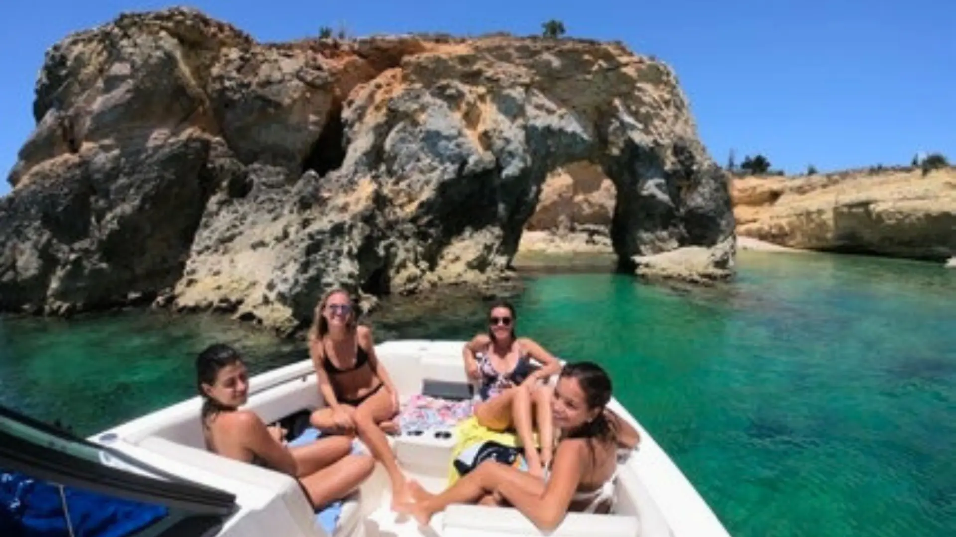 Group relaxing on the bow of a private boat near Anguilla’s famous natural arch