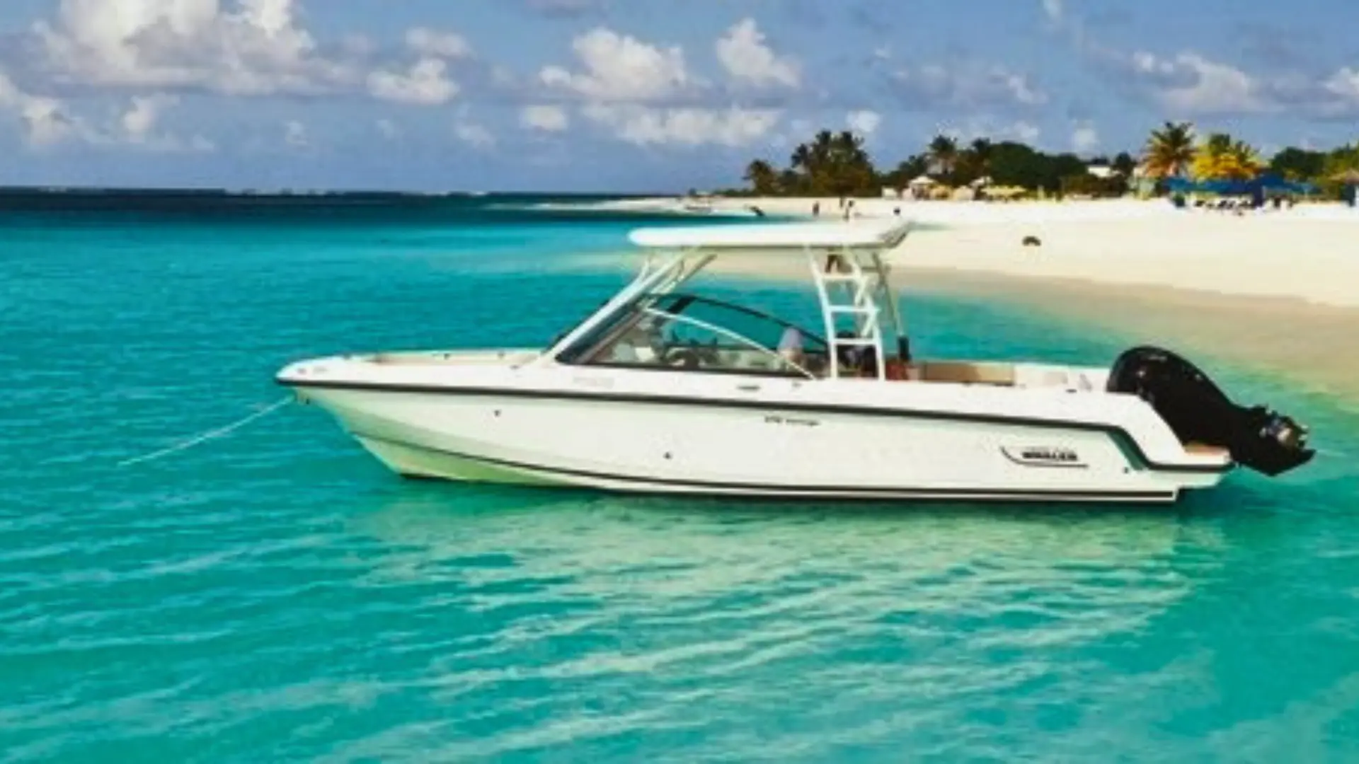 Private boat anchored off a white-sand beach with turquoise water in Anguilla