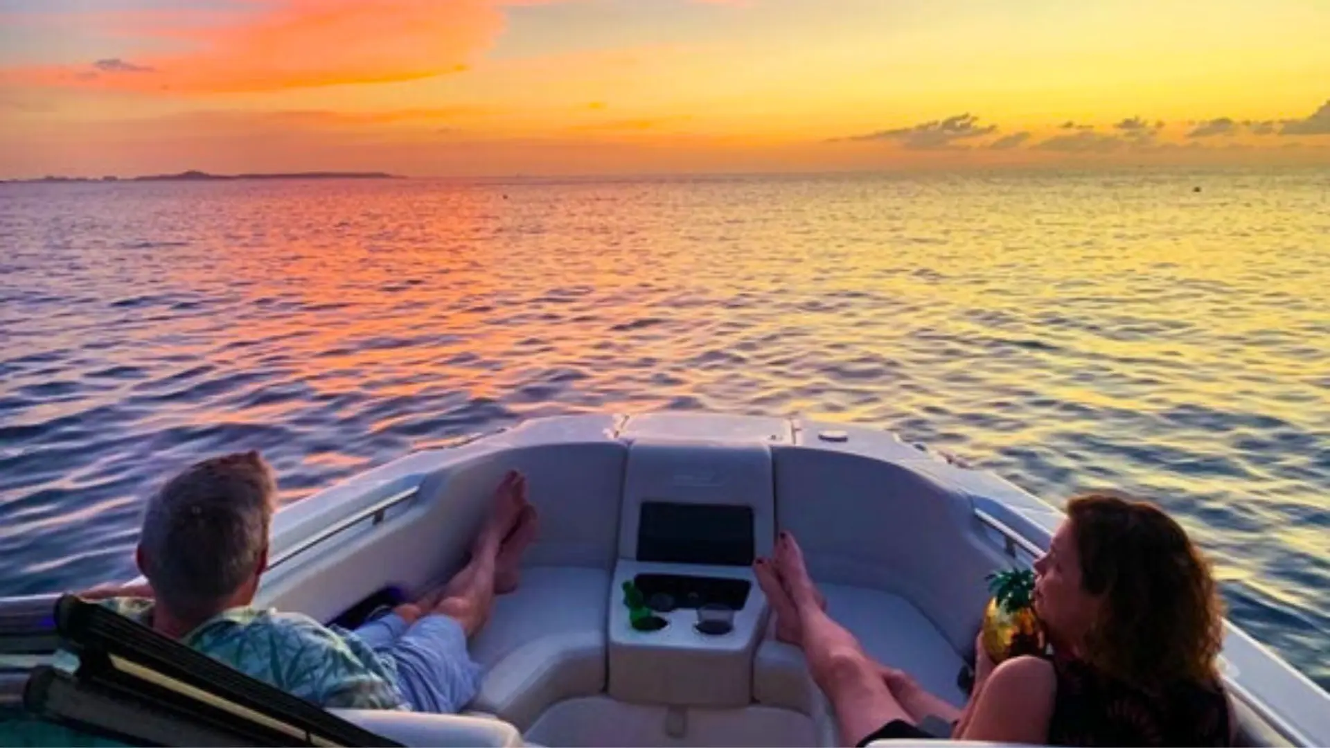 Couple enjoying a private sunset cruise in St Maarten with golden sky views