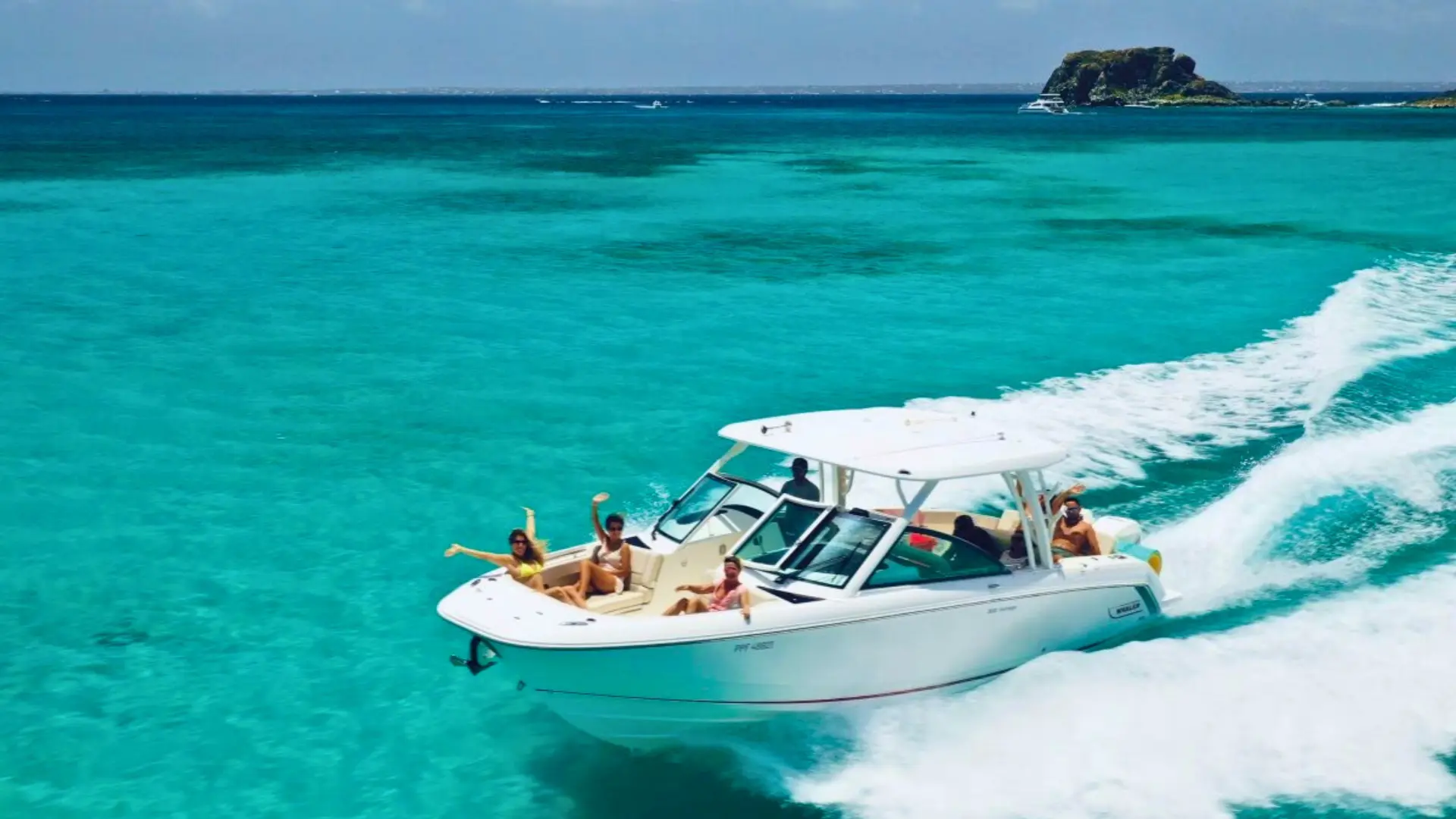 Private charter boat cruising across turquoise waters near St Maarten with guests relaxing on the bow