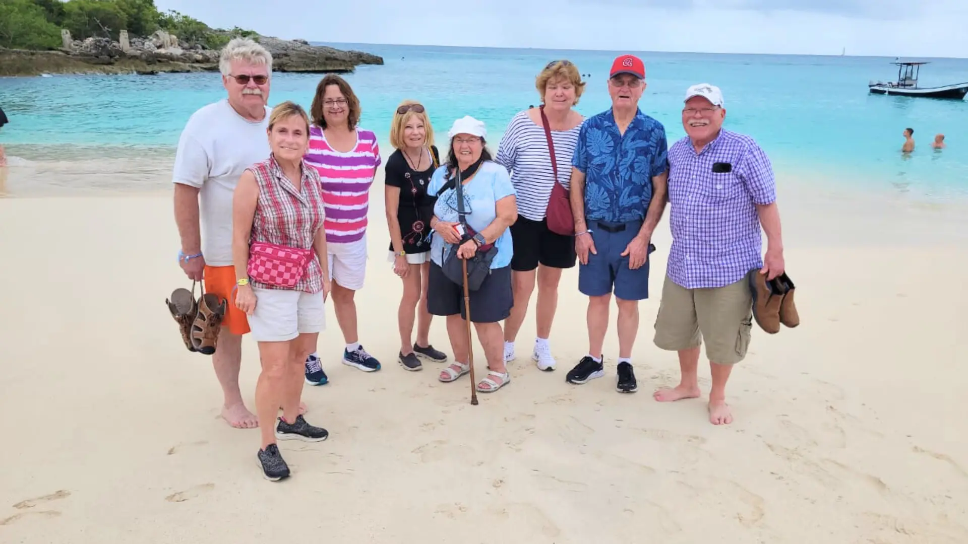 Group photo on a white-sand beach during a guided island tour in St Maarten