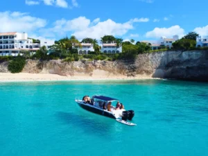 Private boat charter moored off the coast of Anguilla with a group relaxing on board near a sandy beach