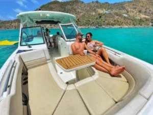 Couple relaxing on motorboat bow seating in turquoise Caribbean waters