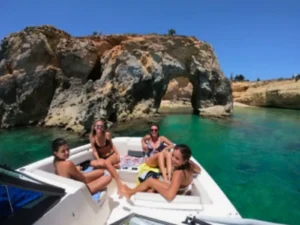 Group relaxing on private boat near rocky coastline in St Martin
