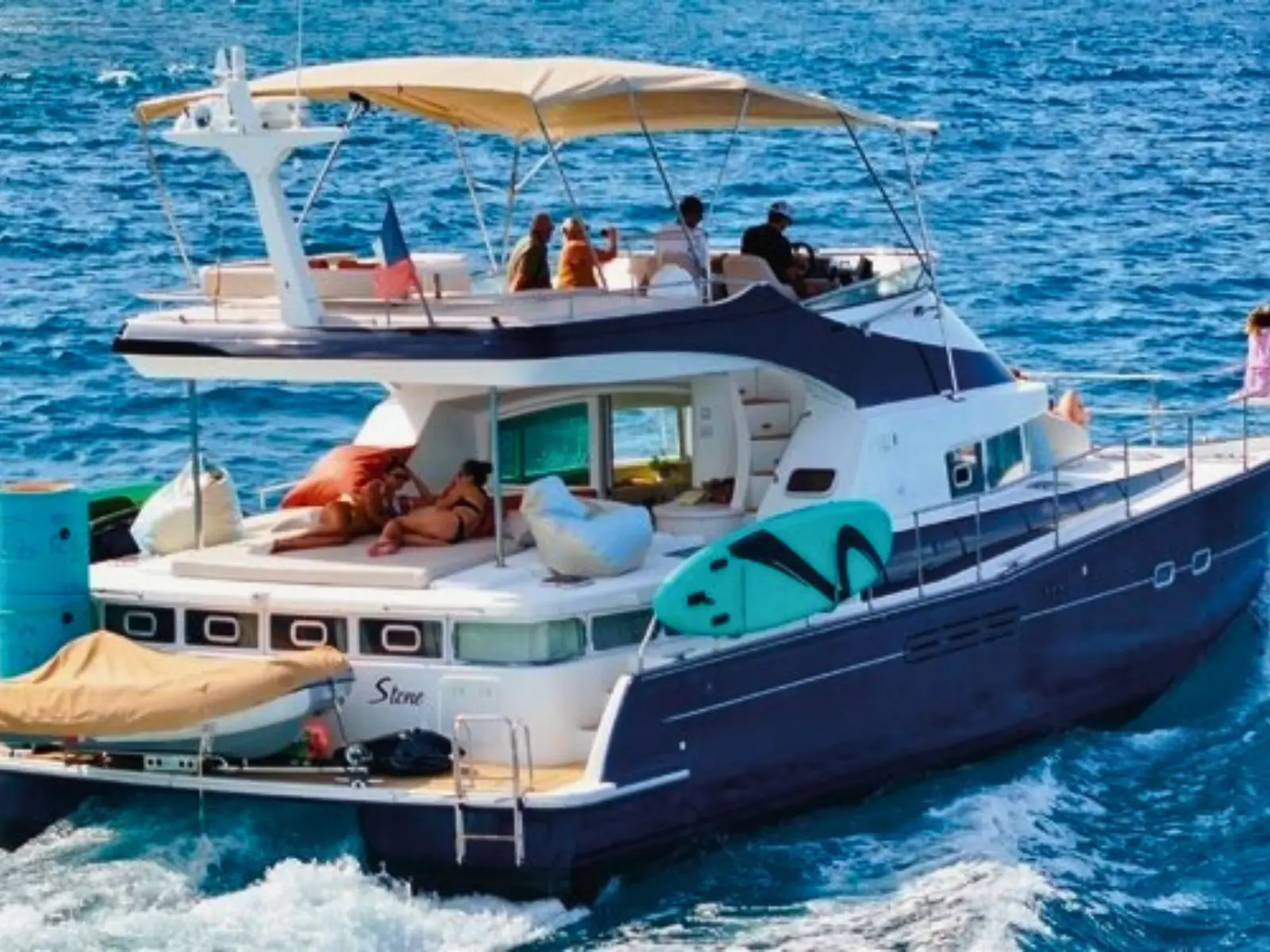Power catamaran underway with guests on upper and lower decks in open sea