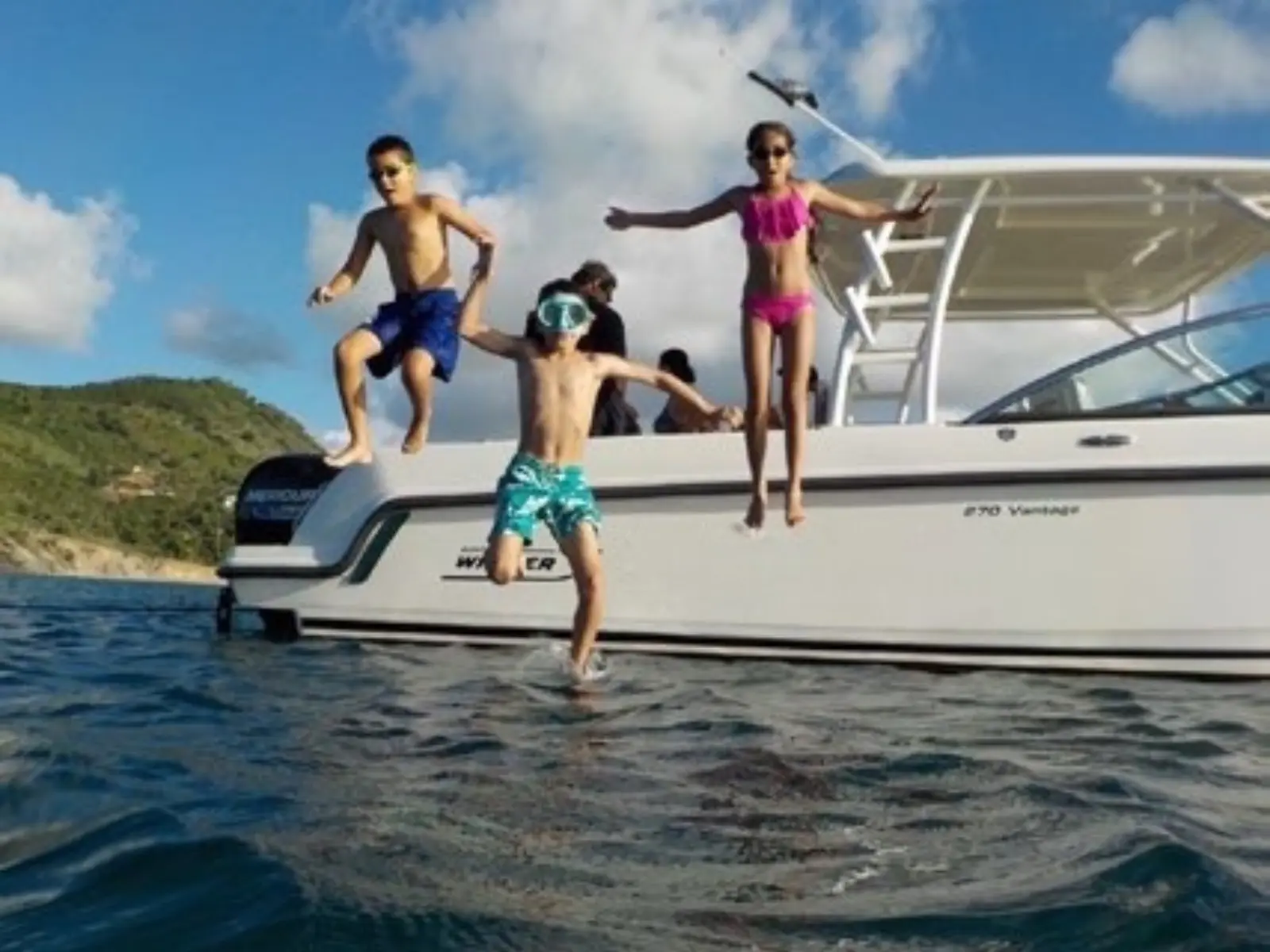 Children jumping into the sea from private boat in St Martin