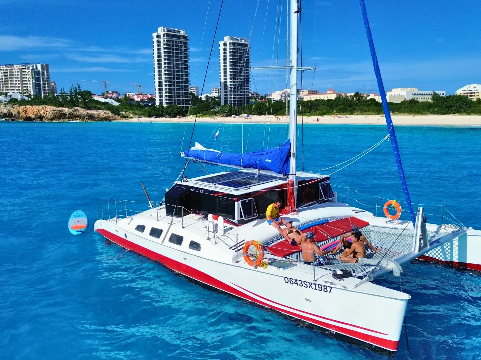 Private catamaran anchored off Orient Bay in St Maarten with guests relaxing on deck and trampoline nets