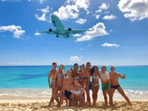 Guests on Maho beach with plane landing above