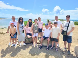 Multi-generational family group posing at a coastal viewpoint during an island tour in St Martin