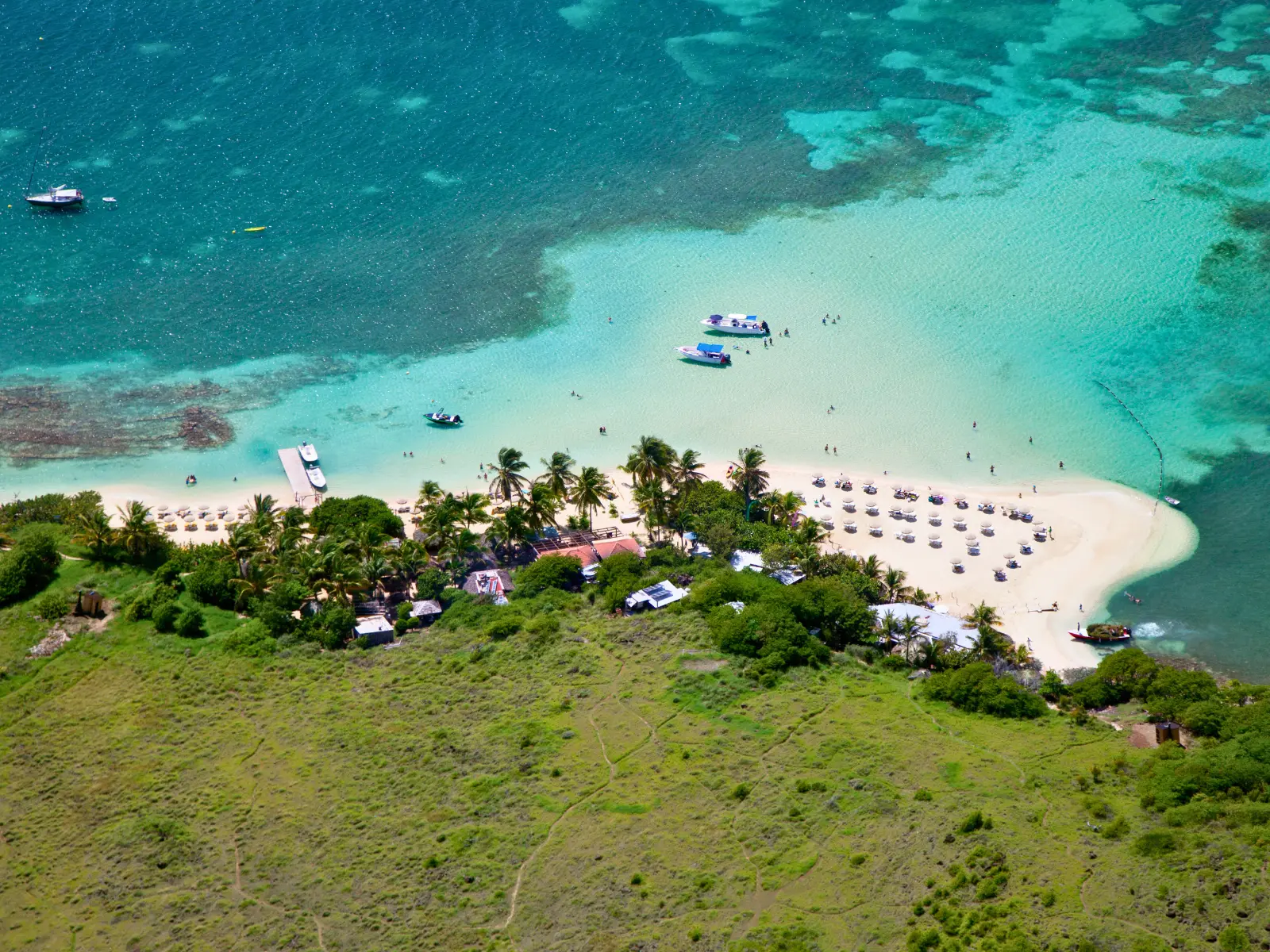 Aerial view of Pinel Island in St Martin with shallow turquoise water, anchored boats, and sandy beach