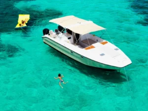 Private power catamaran charter floating in shallow turquoise waters with guests swimming nearby in St Martin