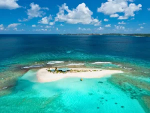 Small boat anchored near Sandy Island in Anguilla with crystal-clear water