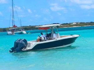 Private motorboat anchored in shallow turquoise water with sailboats nearby, St Maarten
