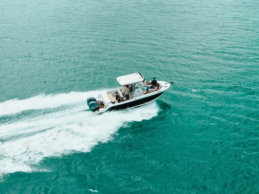 Drone view of a private speedboat cruising fast across turquoise water, St Maarten