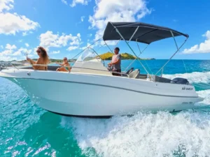 Small private boat charter in St Maarten with shaded canopy and guests enjoying Caribbean cruise