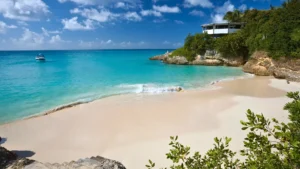 Small private boat anchored in a quiet Anguilla bay with white sand beach and clear water