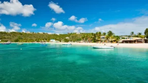 Boats anchored near a beach in Anguilla with calm water and beachfront restaurants