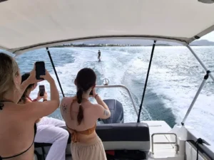 Wakeboarding behind a private boat charter in Saint Martin with guests watching onboard