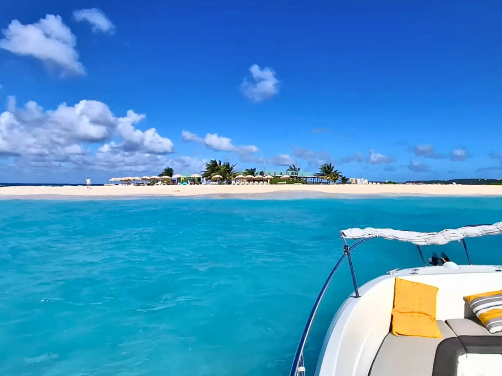 Private boat arriving at Sandy Island Anguilla with white sand beach and turquoise water