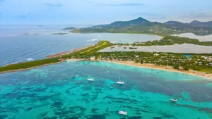 Aerial view of St Martin coastline with turquoise water and boats anchored near shore