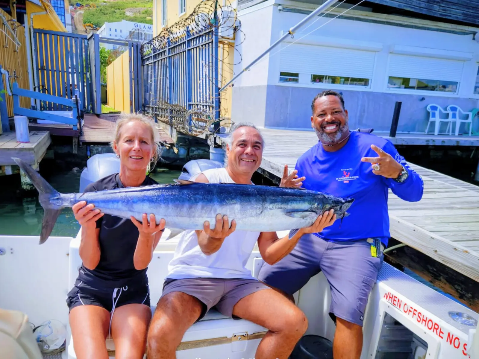 Guests celebrating large wahoo catch after fishing charter in St Maarten