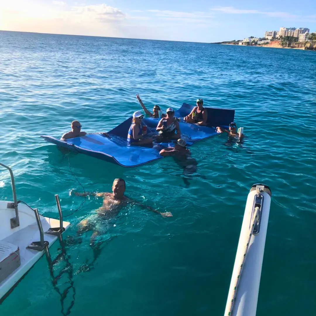 Guests relaxing on floating mat during a St Martin boat charter stop