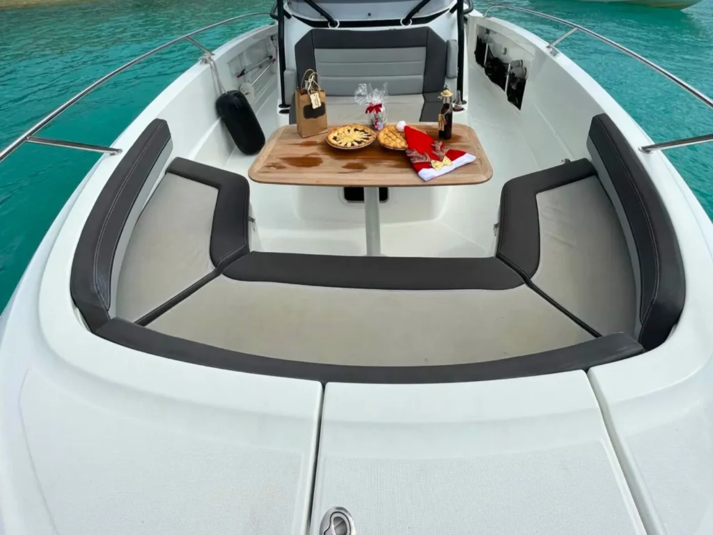 Front seating area with table setup on private boat charter in turquoise waters St Martin
