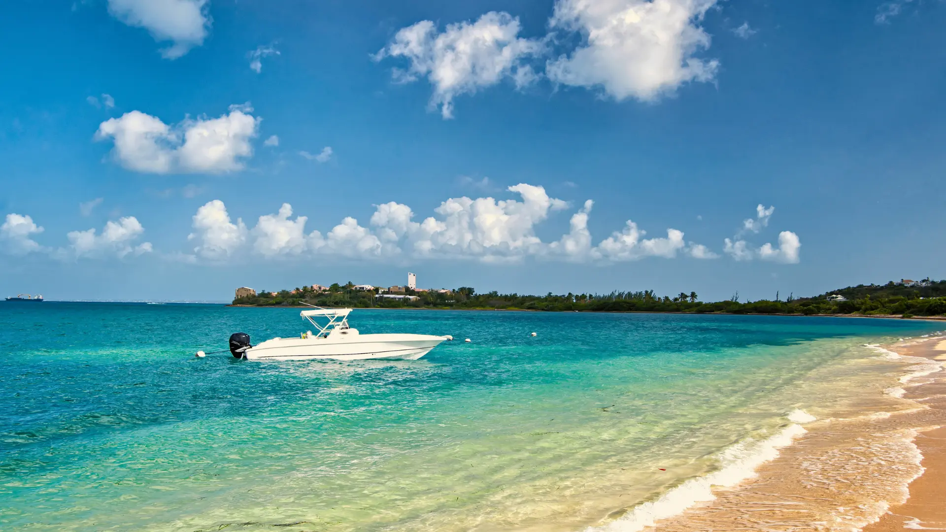 Private boat anchored near beach in St Martin with clear turquoise water