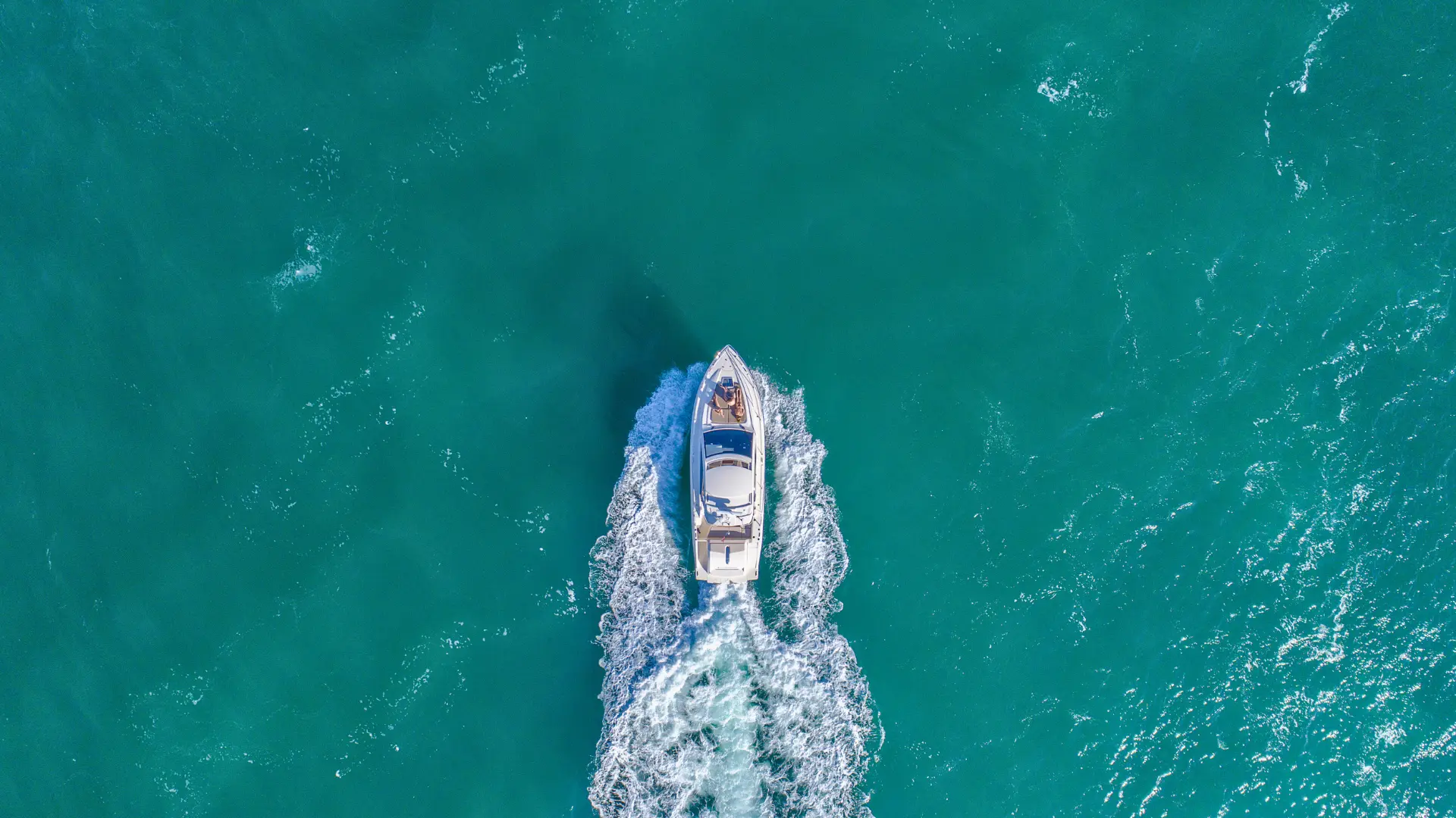Aerial view of private motorboat cruising in turquoise water in St Martin