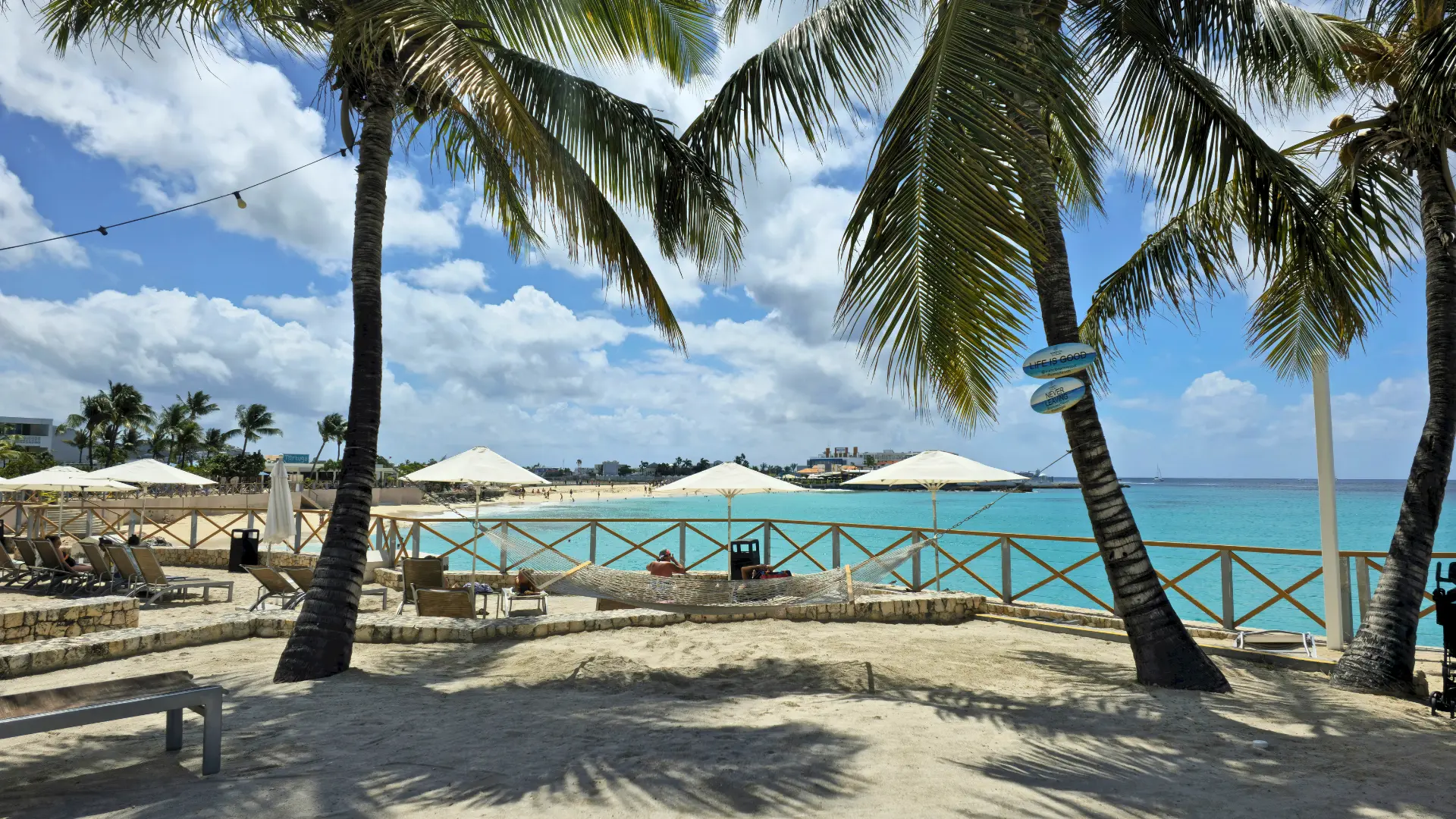 Mullet Bay beach in St Maarten with palm trees, white sand, and calm Caribbean water