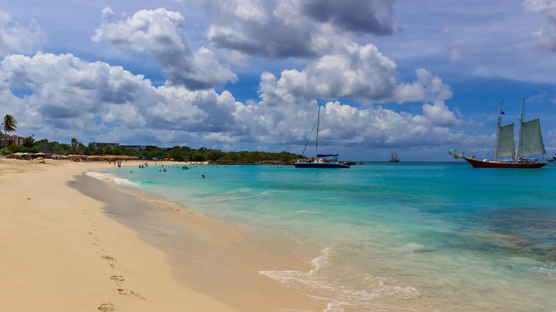 Calm beach at Mullet Bay and anchored boats in St Maarten during private cruise ship excursion from Philipsburg