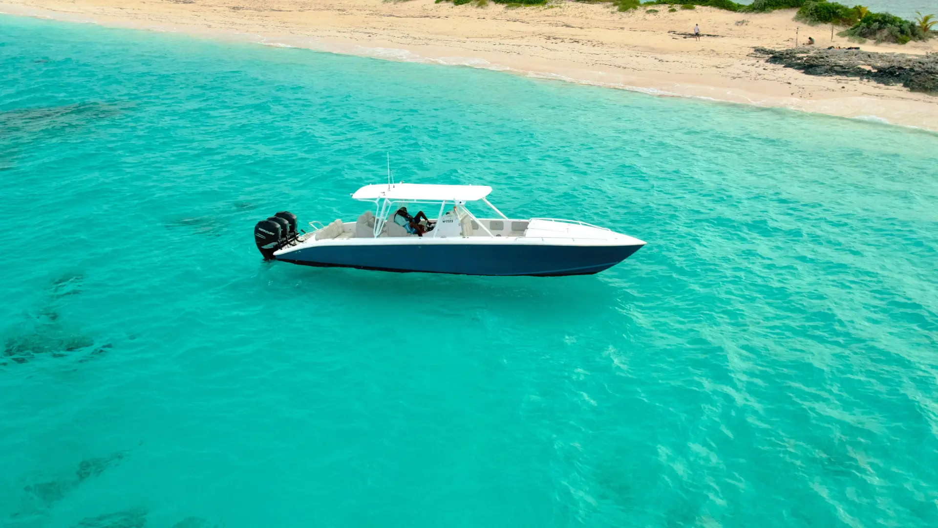 Private motorboat anchored near a quiet beach in St Maarten with crystal clear water