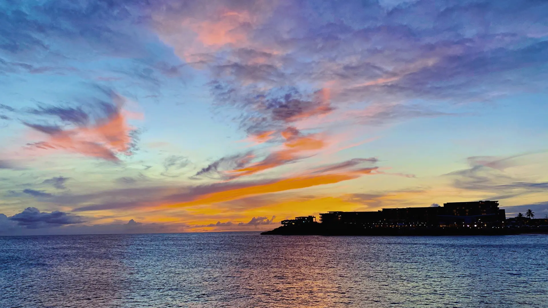 Sunset over the coastline in St Maarten with colorful sky and calm ocean