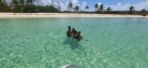 Family in Anguilla's crystal clear water at the beach