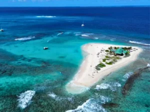 Aerial view of Sandy island with a private boat moored offshore