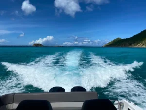 Creole Rock on the horizon with the private boat charter's wake in St Martin